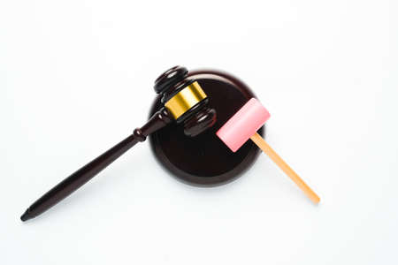 A flatlay picture of gavel and toy hammer on copyspace white background for ambition concept. The ambition of this kid to be a law judge.の写真素材