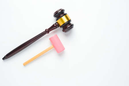 A flatlay picture of gavel and toy hammer on copyspace white background for ambition concept. The ambition of this kid to be a law judge.の写真素材