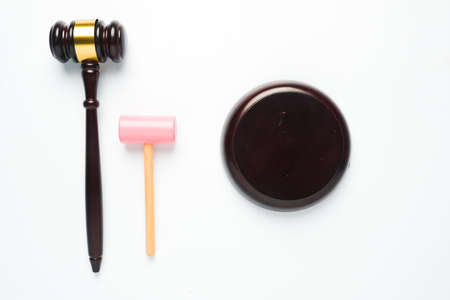 A flatlay picture of gavel and toy hammer on copyspace white background for ambition concept. The...