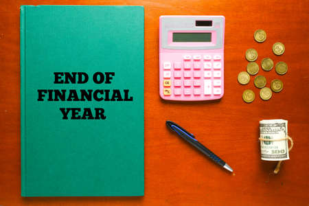 Flatlay picture of green account manuscript book written End Of Financial Year with calculator, pen, fake cash and coin forの写真素材