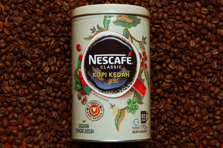 Limited edition Nescafe Classic Kopi Kedah canister lying on coffee beanのeditorial素材