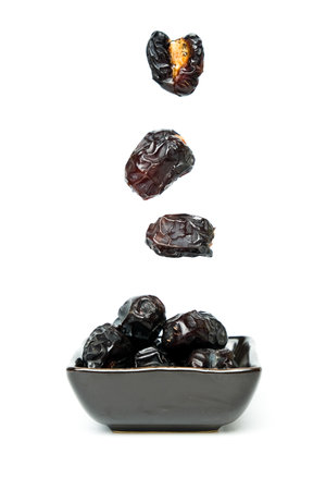 A levitation picture of "ajwa" date on white background. Ajwa date is the most preferred by Prophet Muhammad.の写真素材