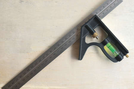 A picture of L shape angle ruler with fluid balancer on the wood.