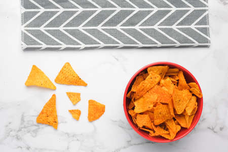A flatlay picture of nachos in a bowl with grey cloth on marble table. Nachos are a Mexican regional dish from northern Mexican often served as a snack or appetizer.の写真素材