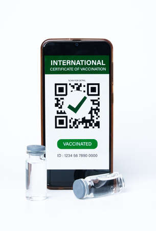 A picture of smartphone with fake International Certificate of Vaccination on it and two doses of vaccine insight. Rate of vaccination is not good in many countryの写真素材