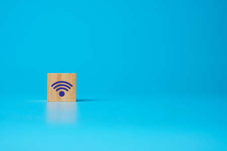 A picture of WIFI signal at wooden block on blue copyspace background.の写真素材