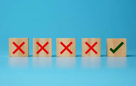 A picture of wooden block with cross and right sign. Try and error concept