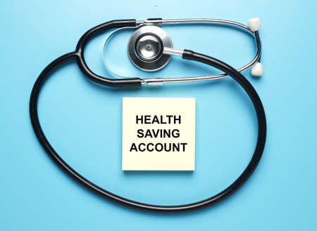 Stethoscope and notepad written Health Saving Account. Health financial plan.