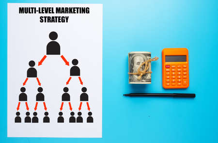 Paper with Multi-level marketing diagram, fake money, calculator and pen. MLM structure and explanation for road to success.の写真素材