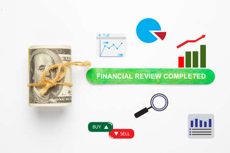Fake money, with other finacial symbol and green ice cream stick written Financial Review completedの写真素材