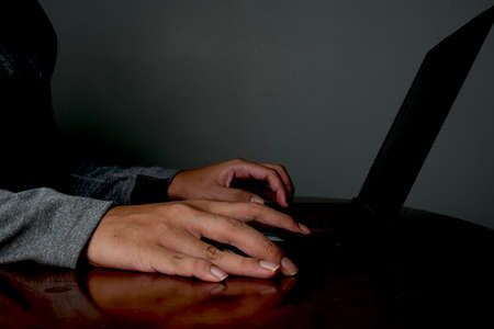 A low exposure picture of hand with mouse and keyboard for hacking and cyber security concept.の写真素材