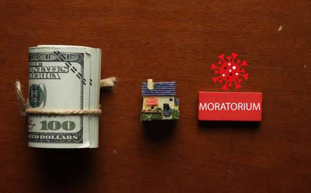 A picture of house miniature, house insight, coronavirus and red wooden block written MORATORIUM. Moratorium is a length of time during which you enjoy a holiday from loan.の写真素材