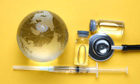 A picture of vaccine and stethoscope with glass globe insight. Take care of ousrselves during this pandemicの写真素材