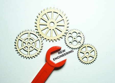 A picture of wooden gear, toy spanar and new engineering word on white backgroundの写真素材