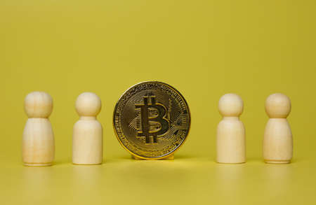 Selective focus of Bitcoin with peg dolls insight. Bitcoin and crypto currency education concept.