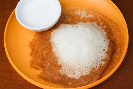 A close up picture of apom lenggang with sweet milk on plate. Traditional food made of cold rice,...