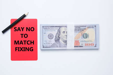 A red card written say no to match fixing and fake dollar insight. War against match fixing concept.