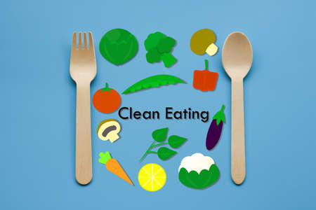 A picture of wooden spoon with vegetables illustration and clean eating word. Clean eating is the health benefits of consuming foods rich in nutrient content directly from the earth that have not been overly processed.の写真素材