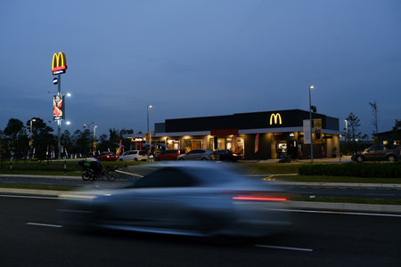 "Rimbayu, Malaysia- Circa February, 2022: Long Exposure and selective focus picture with noise effect of Mcdonald's restaurant during at night. Car passing by in slow shutter"のeditorial素材