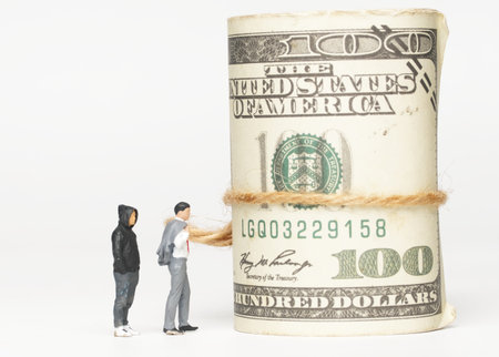 A picture of men miniature with fake money. Finacial burden and debt.の写真素材