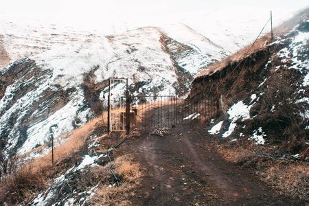 The road in the rocky mountains against the mountains with snow