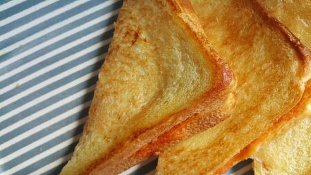 Closeup view of freshly prepared half fried slices of toast bread. Food background for bakery...