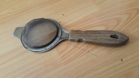 Close up view of chinois with metal gaze place on a wooden floor. This chinois is use for tea...