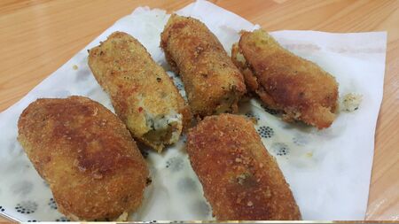 Closeup perspective view of home made spicy and delicious croquettes served in ceramic plate over...