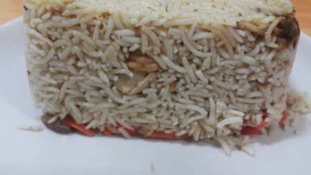 Closeup of frozen white rice cake in a white plate over wooden floor. Healthy food concept.の写真素材