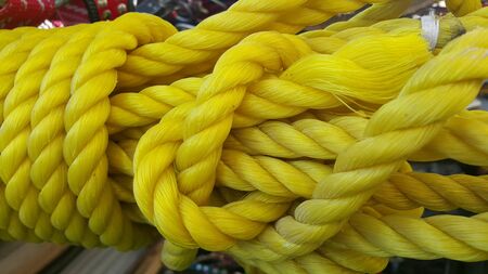 Closeup of bright color braided plastic ropes. Hanks or coil of bright colored plastic rope interwoven which are used for climbing and tightening materials.の写真素材