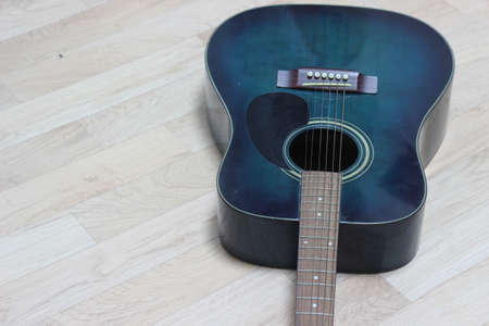 Close up of music guitar. Acoustic guitar with strings on a wooden floor