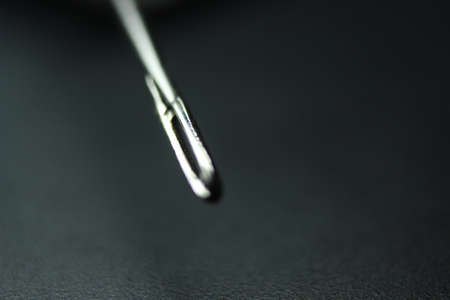 Macro photograph of sewing needle. Small needle with empty eyelet, isolated over the black background.の写真素材