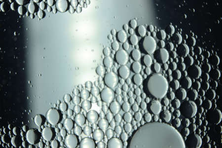 abstract macro background of oil circles floating over water surface . Macro closeup view of bubbles...