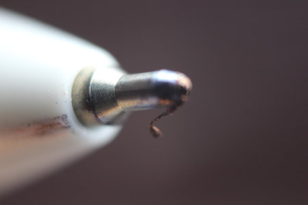 Macro photo of ballpoint pen tip with dark grey background. Extreme macro image of metal ballpoint pen on grey background.の写真素材