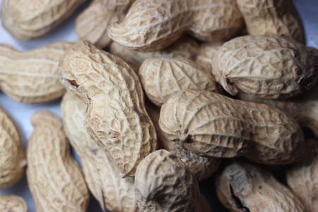 Unpeeled peanut with shells. Food background of peanuts