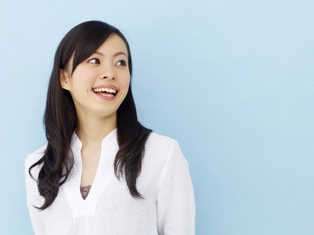 Happy young japanese girl isolated on blue backgroundの写真素材