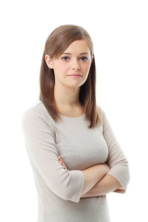 Young woman standing with folded hand against white background の写真素材