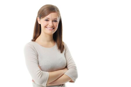 Young woman standing with folded hand against white background の写真素材