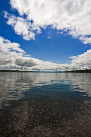 Cloudy blue sky above a blue surface of the seaの写真素材