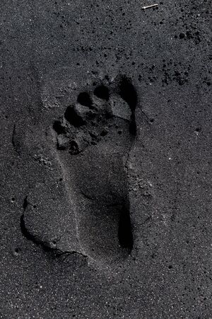 Footprint in black sandの写真素材