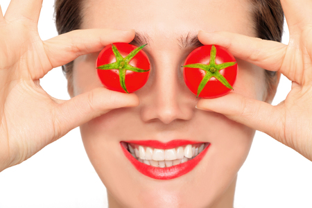 Beautiful woman with tomatoes in her handの写真素材