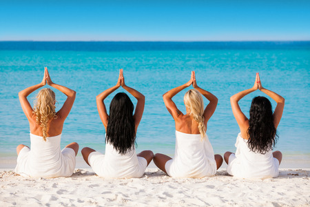 Girls in white towels on a sand beachの写真素材