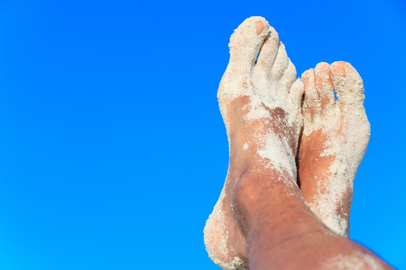 Sandy men feet in the airの写真素材