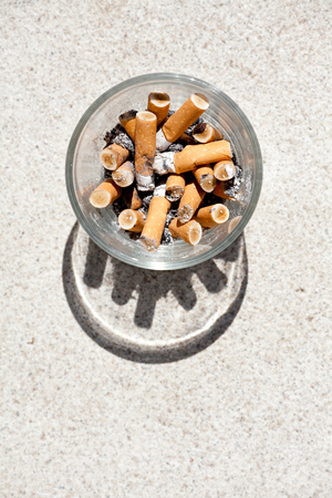 Cigarette butts in the glassの写真素材