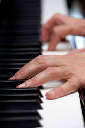 Piano keys with human handの写真素材
