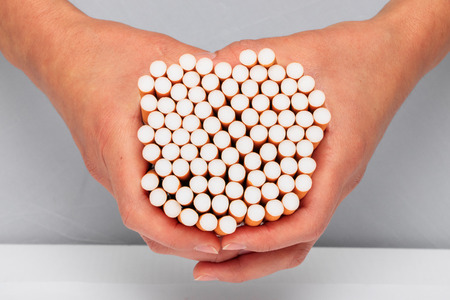 Woman is holding a cigarette in her handの写真素材