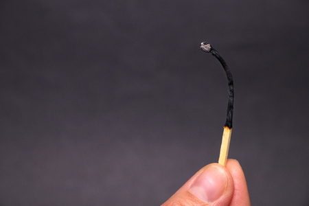 Burning match in female hand, isolated on blackの写真素材