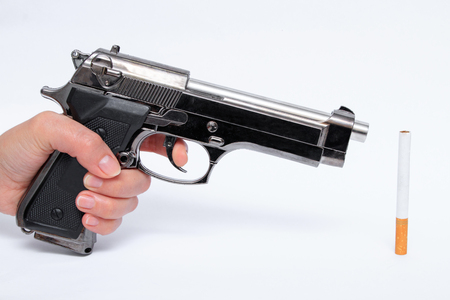 Woman straightens weapon on cigaretteの写真素材