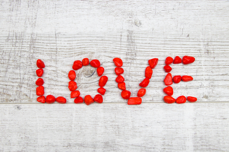 Word love written with red pebbles on the woodenの写真素材