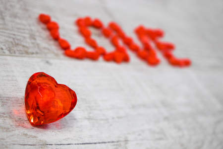 Word love written with red pebbles on the woodenの写真素材